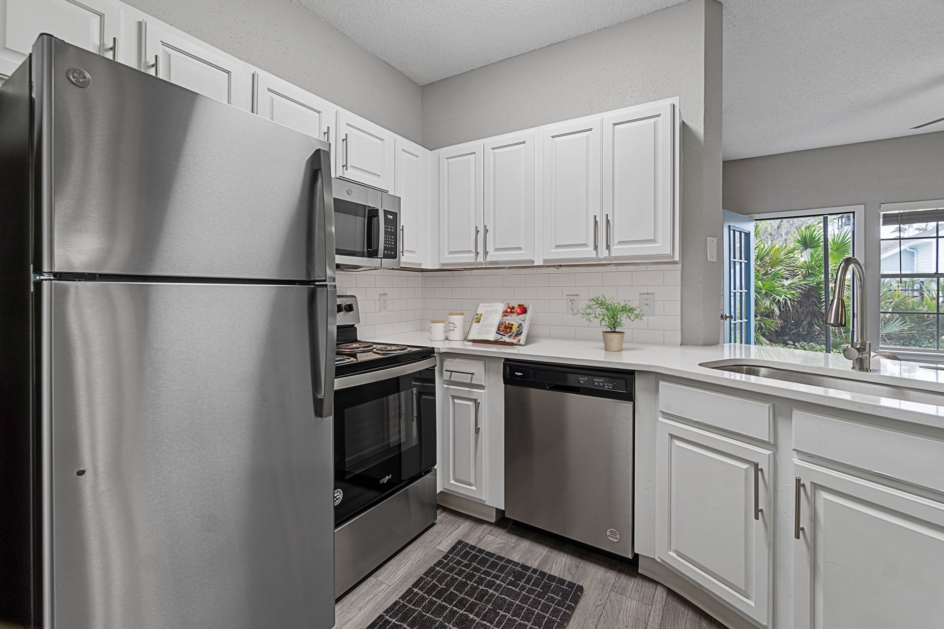 open kitchen with stainless steel appliances, and updated cabinets and hardware